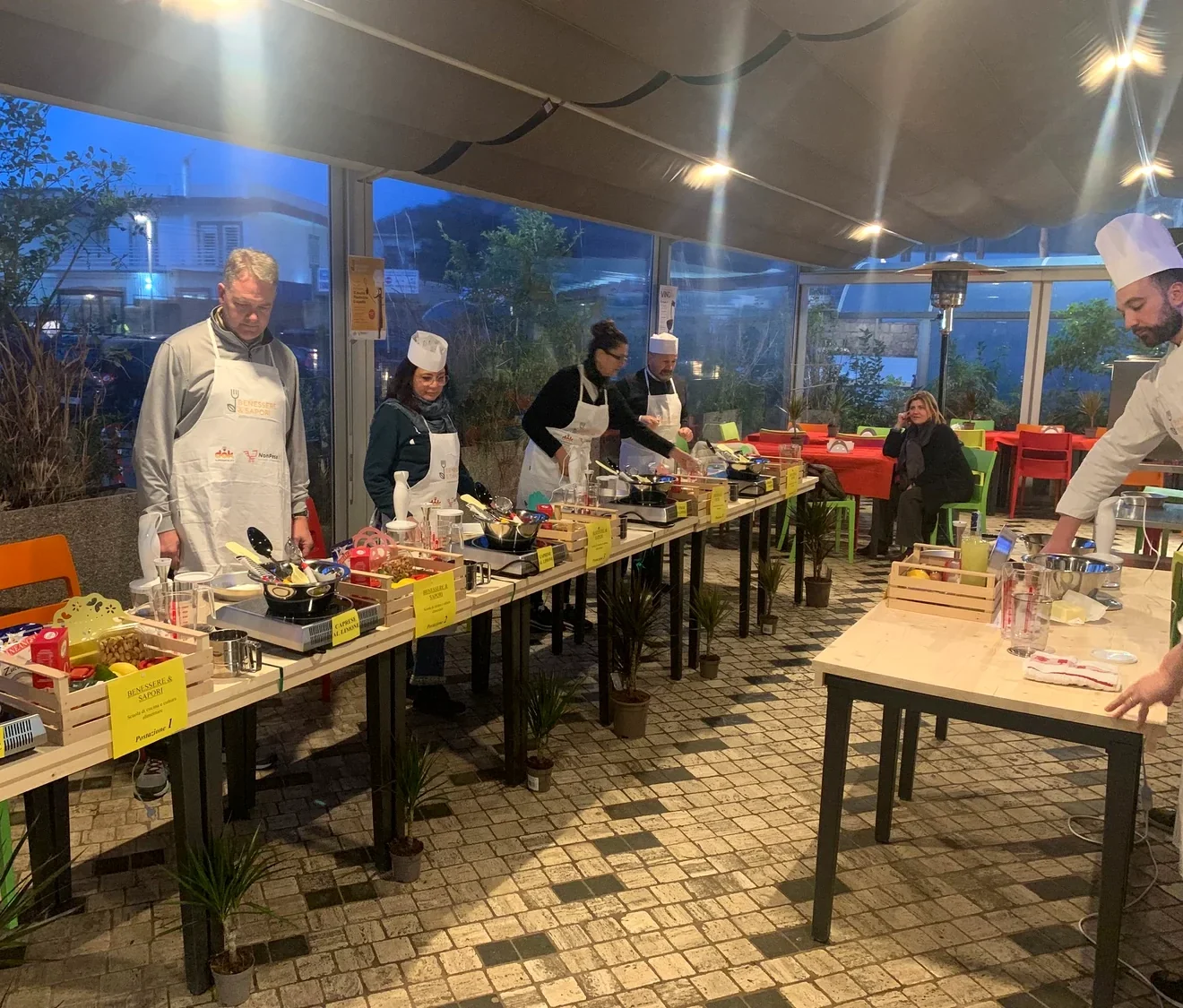 Clienti ai fornelli durante un corso di cucina Benessere e Sapori organizzato da Dok